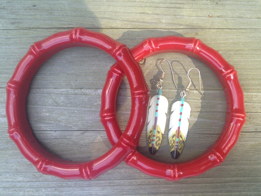 red bracelets and feather earrings